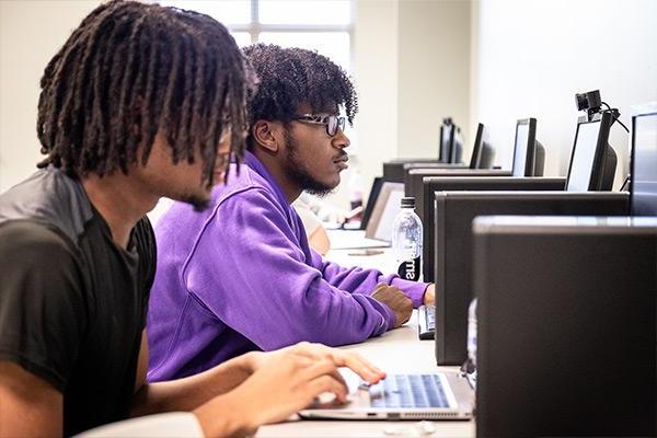 Row of students working on computers in computer lab